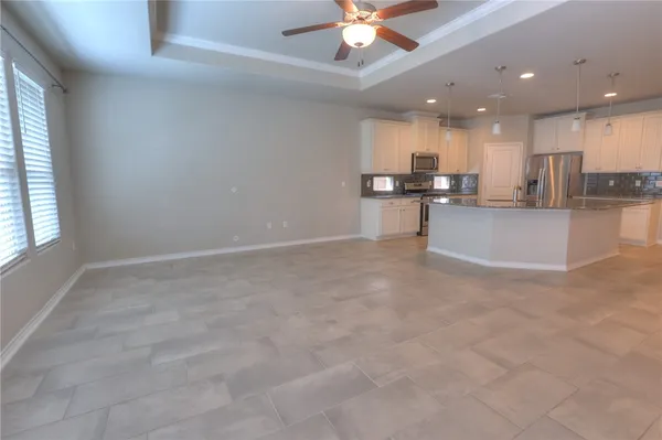 a view of a kitchen with kitchen island a sink wooden floor and a living room view