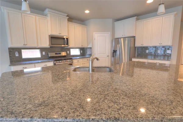 a view of kitchen with sink microwave and refrigerator