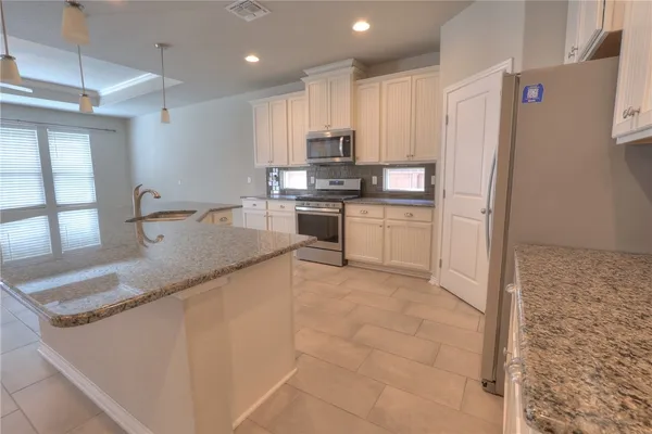 a kitchen with stainless steel appliances granite countertop a sink stove and refrigerator