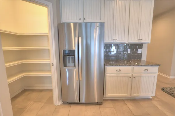 a kitchen with cabinets and a refrigerator