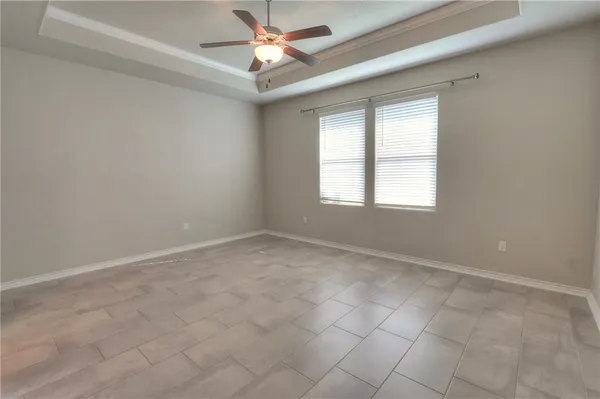 an empty room with a window and a fan