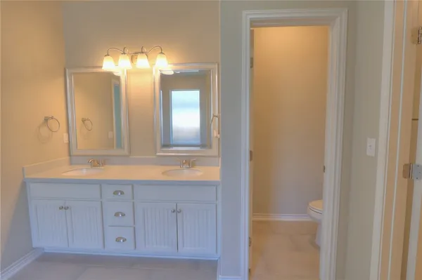 a bathroom with a double vanity sink and a mirror