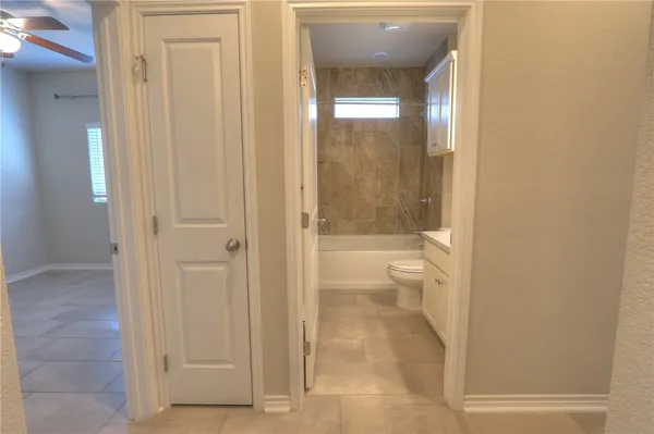 a bathroom with a granite countertop toilet and a shower
