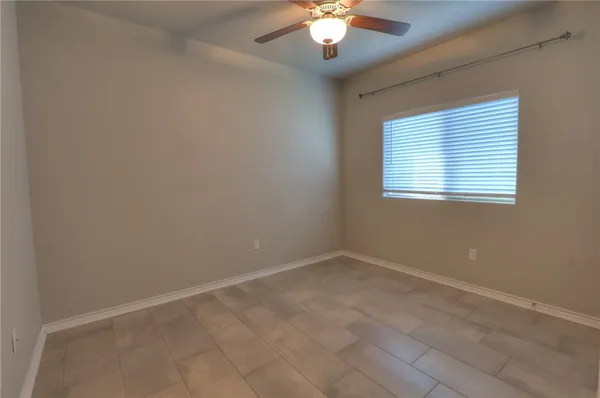 an empty room with chandelier fan
