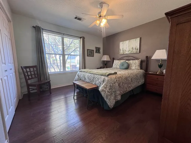 a bedroom with a bed chandelier and a window