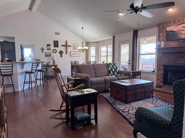 a living room with fireplace furniture and a large window