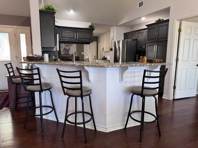 a kitchen with a table chairs refrigerator and cabinets