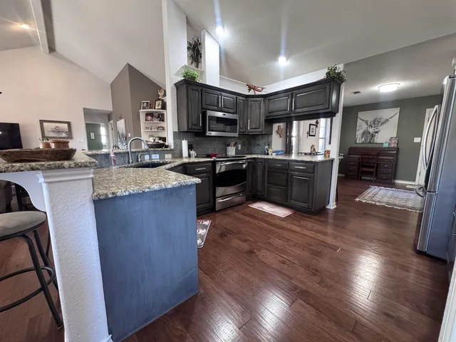 a kitchen with granite countertop stainless steel appliances and wooden cabinets