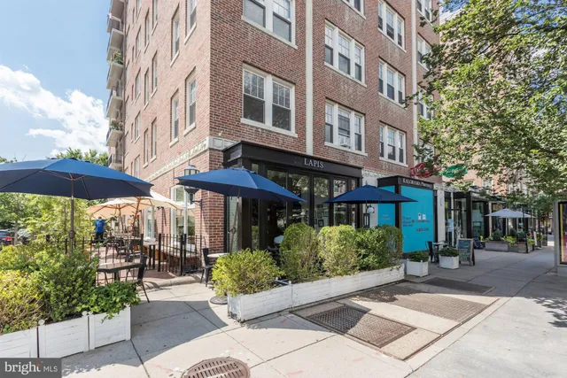 a street view with tall buildings and cars parked on road