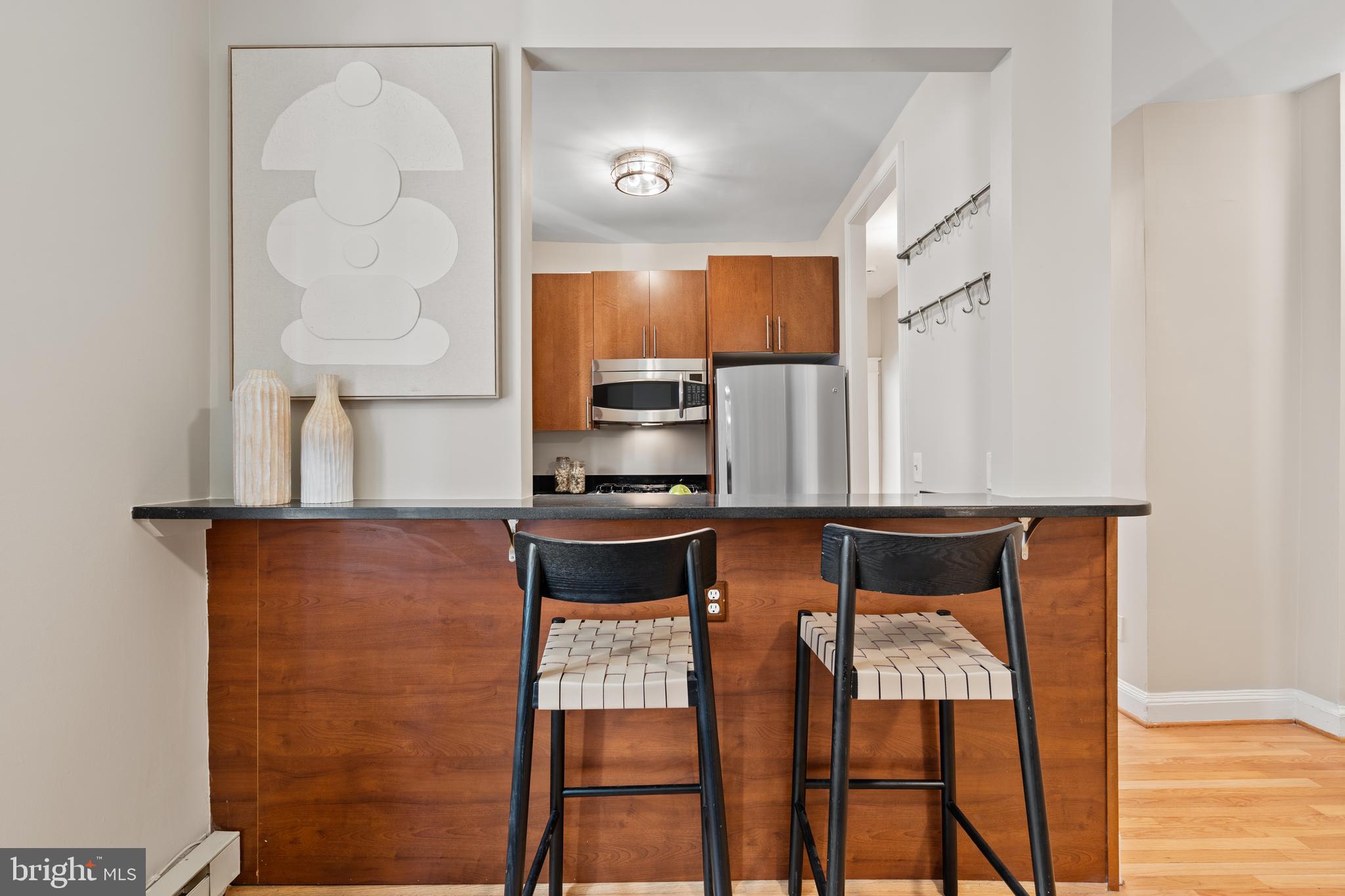 2010 Kalorama Road Northwest, Unit 306 Washington, DC 20009 - Photo 7 of 26 a kitchen with stainless steel appliances cabinets and chair