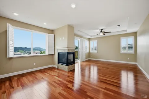 a view of empty room with wooden floor and fireplace