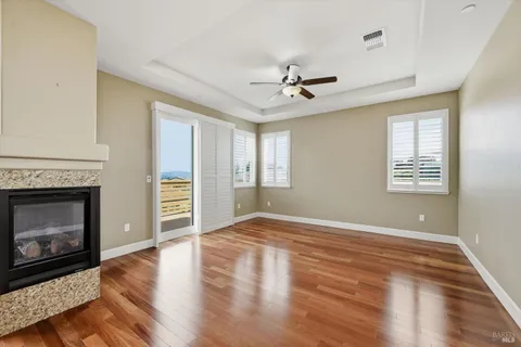 a view of empty room with wooden floor and fireplace