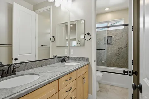 a bathroom with a granite countertop sink mirror shower and double
