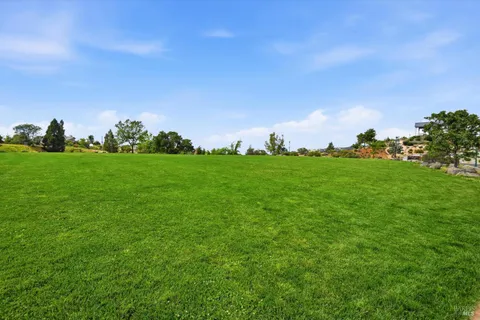 a backyard of a house with lots of green space and mountain view