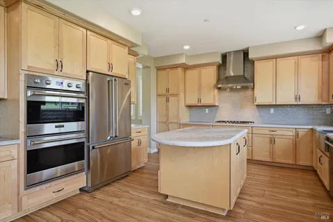 a kitchen with stainless steel appliances granite countertop a refrigerator a stove and a sink