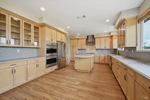 a large kitchen with stainless steel appliances kitchen island granite countertop a stove and a sink
