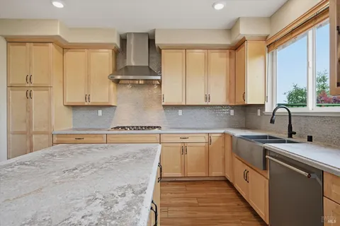 a kitchen with stainless steel appliances granite countertop a stove a sink and white cabinets