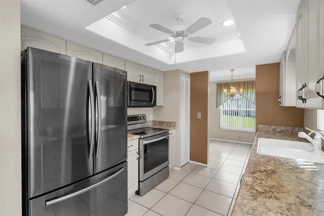 a kitchen with stainless steel appliances granite countertop a refrigerator a stove a sink a washer and dryer