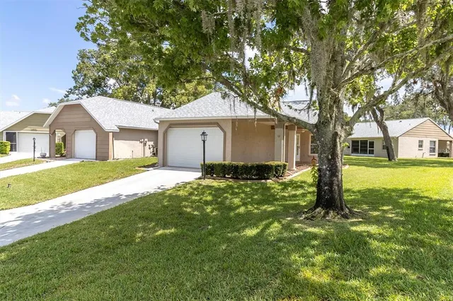 a front view of a house with a yard and trees