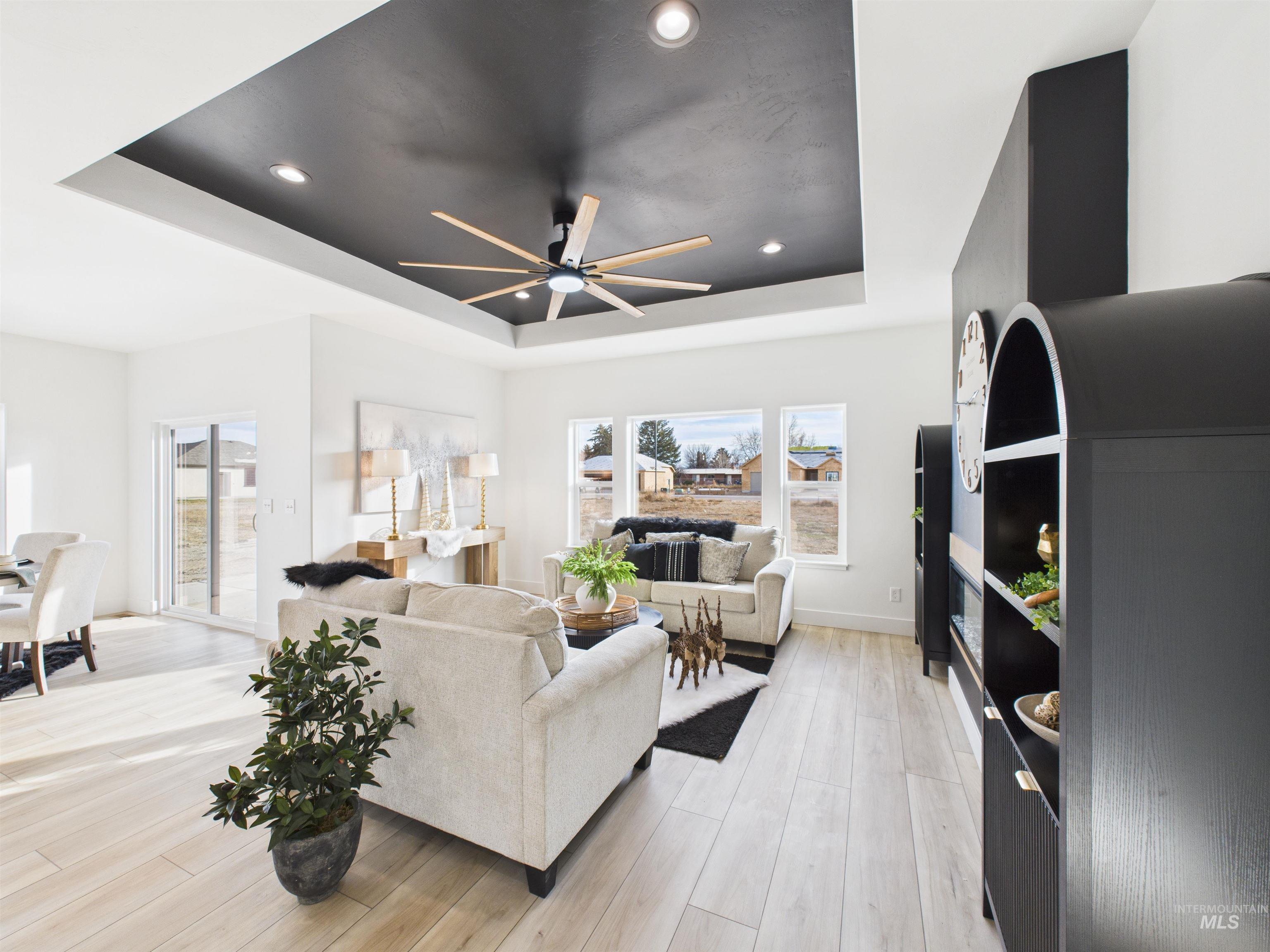 1211 Bronze Rupert, ID 83350 - Photo 12 of 30 Living room with a tray ceiling, light wood finished floors, recessed lighting, healthy amount of natural light, and ceiling fan