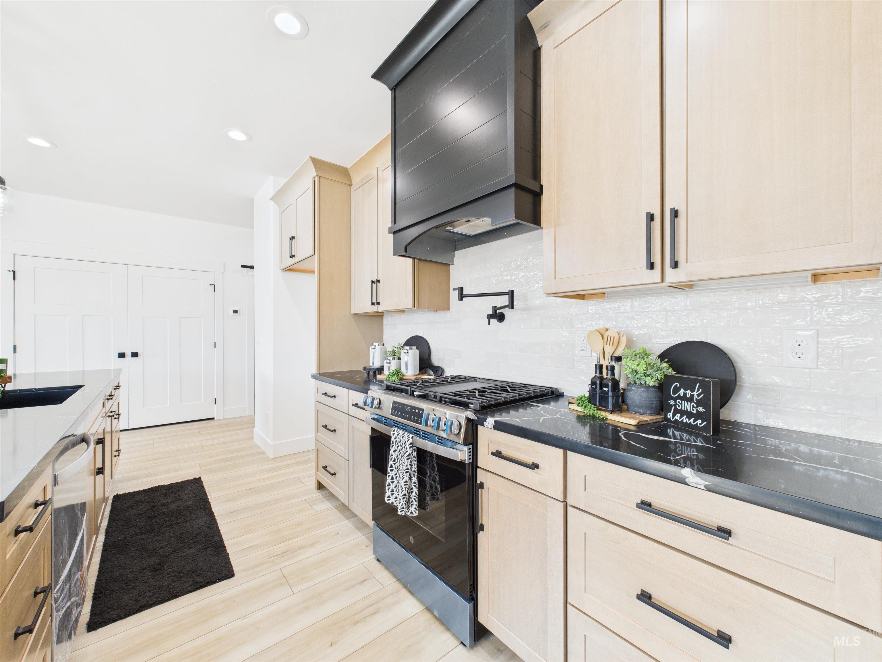 1211 Bronze Rupert, ID 83350 - Photo 7 of 30 Kitchen featuring stainless steel gas range, light brown cabinets, custom range hood, recessed lighting, and backsplash