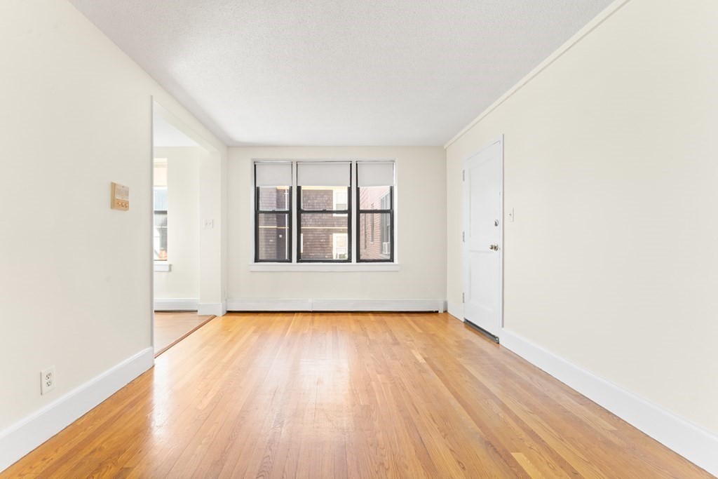11 Victory Road, Unit 32 Boston, MA 02122 - Photo 11 of 16 an empty room with wooden floor and windows