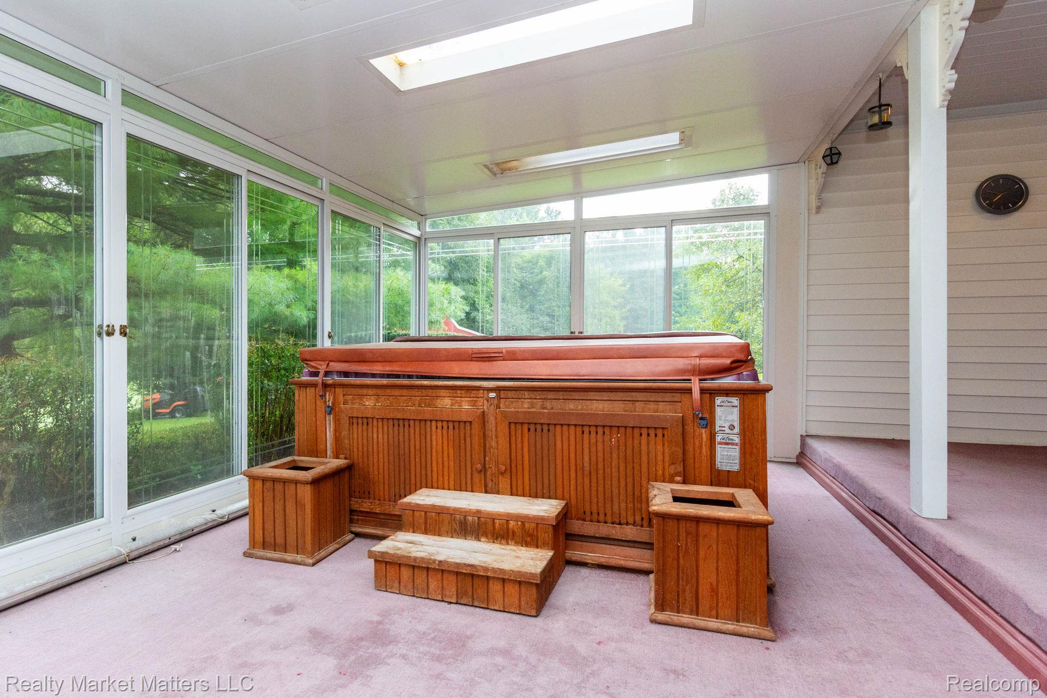 770 North Fairgrounds Road Imlay City, MI 48444 - Photo 13 of 55 Enclosed porch featuring a built-in hot tub, extensive window walls, a skylight, and wall-mounted lighting