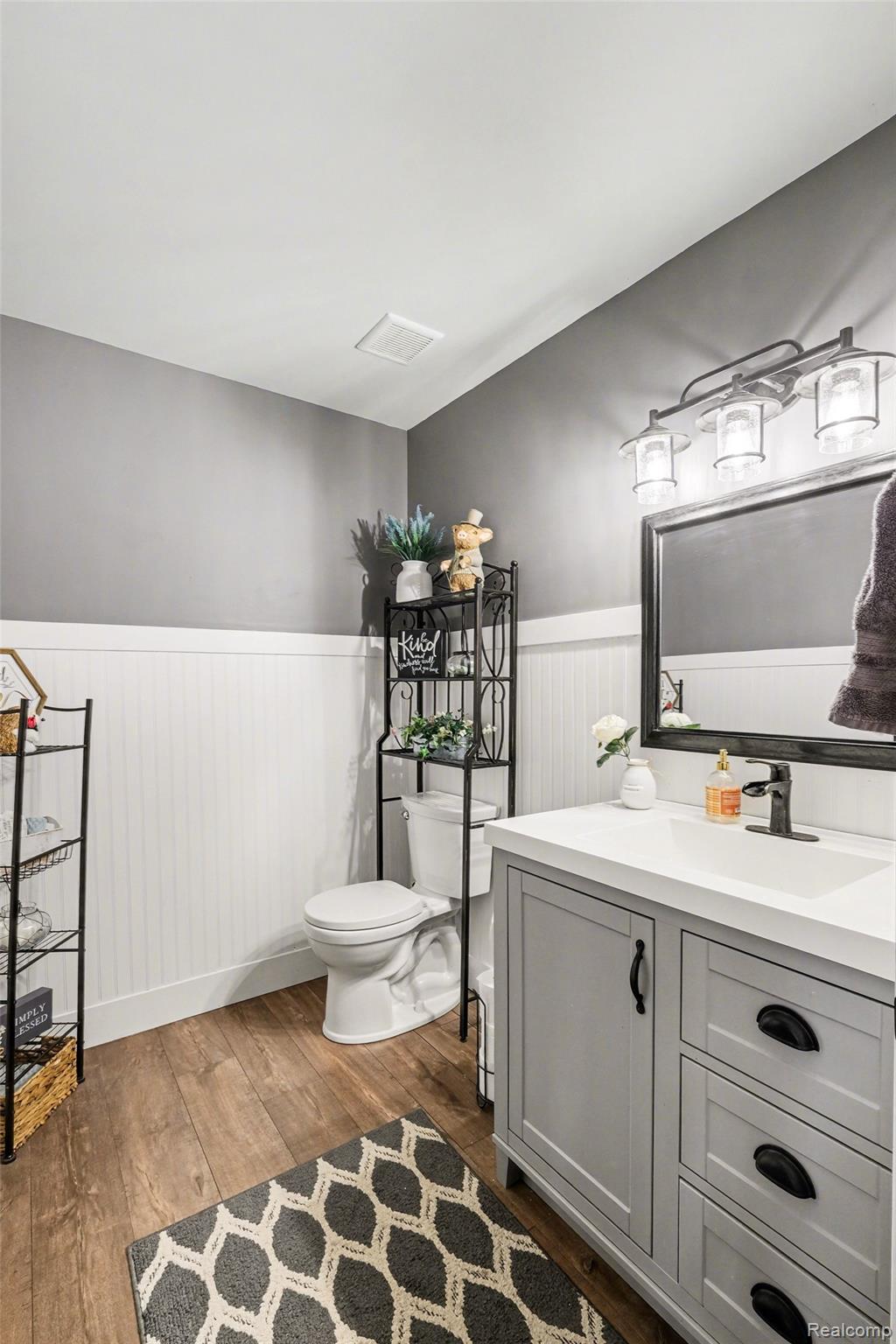 9084 Copper Ridge Drive Davison, MI 48423 - Photo 30 of 42 Bathroom featuring vanity, dark wood finished floors, and a wainscoted wall