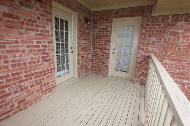 a view of wooden door and brick walls
