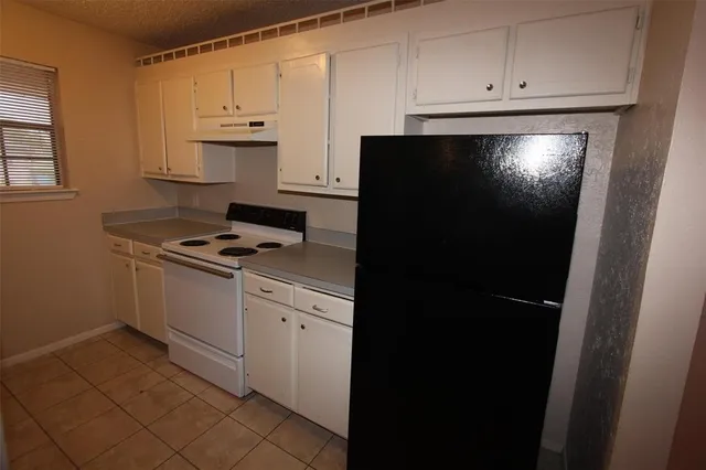 a kitchen with white cabinets and white appliances