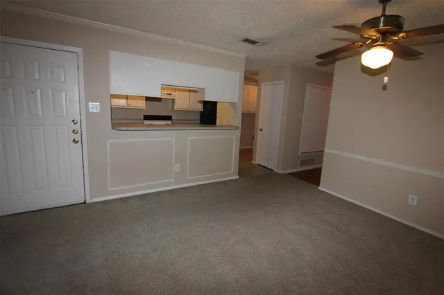 a view of kitchen and empty room with tv