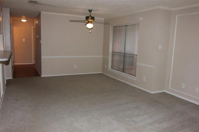 an empty room with chandelier fan