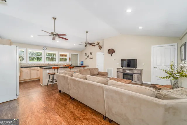 a kitchen with stainless steel appliances granite countertop a stove a sink a microwave and island with wooden floor