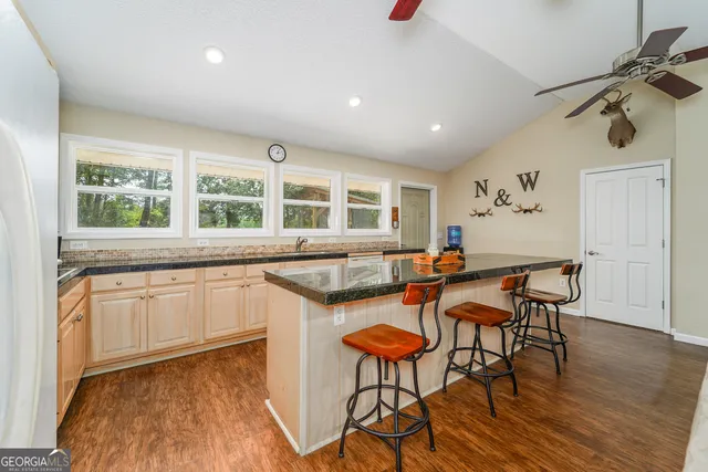 a kitchen with granite countertop white cabinets and a window