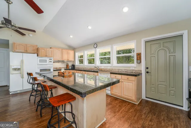 a white kitchen with granite countertop sink and cabinets