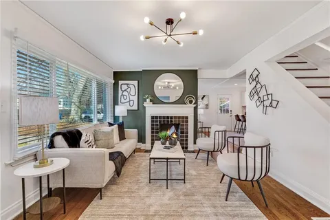 a living room with furniture a large window and a fireplace