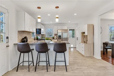 a kitchen with stainless steel appliances kitchen island granite countertop a refrigerator and a stove top oven