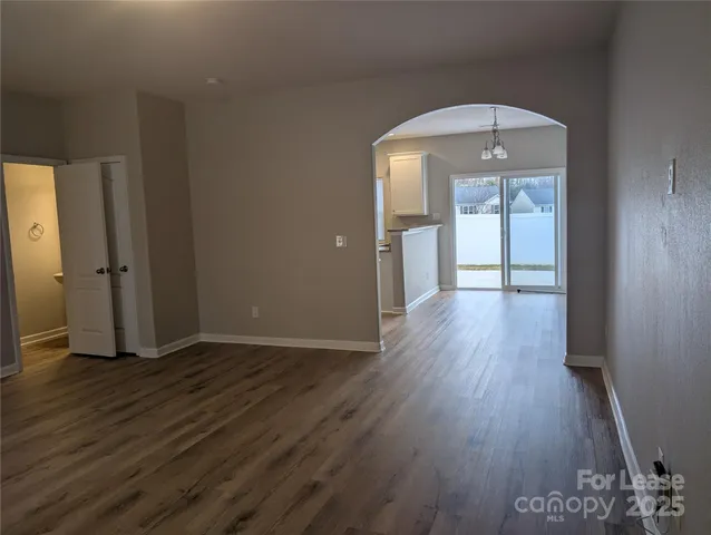 an empty room with wooden floor and mirror