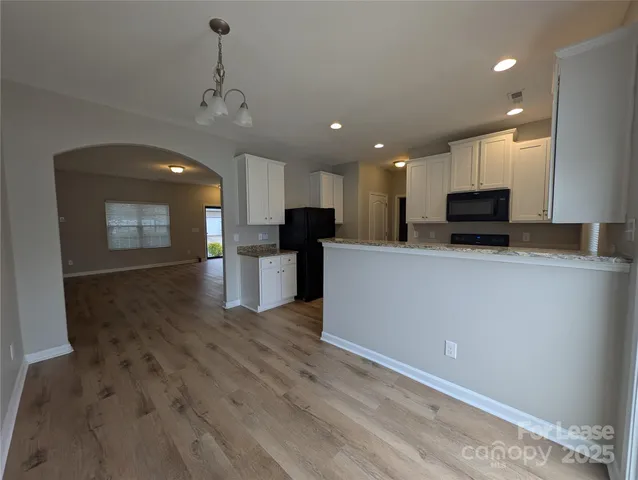 a view of kitchen with microwave and refrigerator