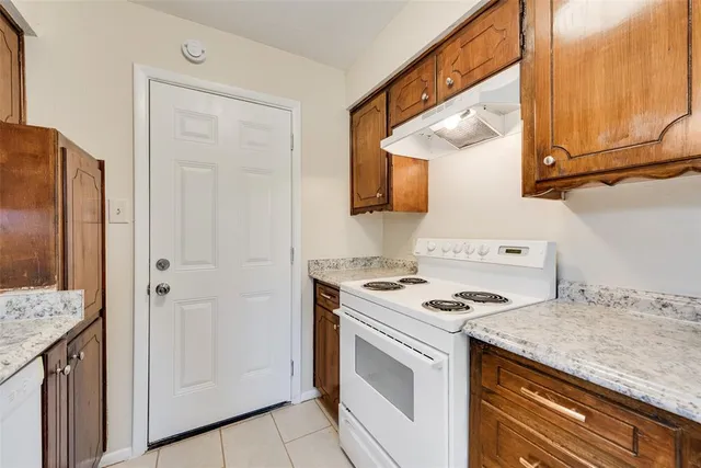 a kitchen with granite countertop cabinets stainless steel appliances and wooden floor