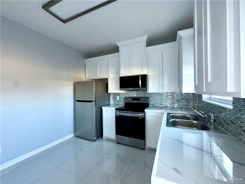 1038 Yellow Hammer Street Rio Grande City, TX 78582 - Photo 3 of 20 a kitchen with a sink and stainless steel appliances
