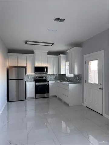 a kitchen with a refrigerator and a stove