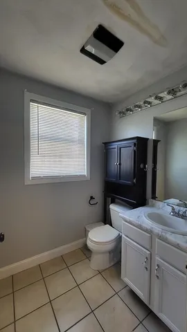 a bathroom with a toilet sink and mirror