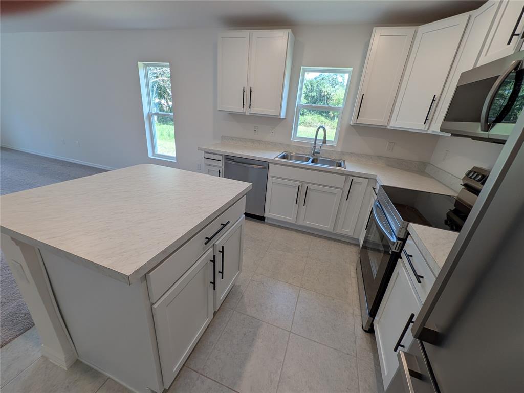9065 107th Court Vero Beach, FL 32967 - Photo 15 of 40 a kitchen with a stove a sink and a window