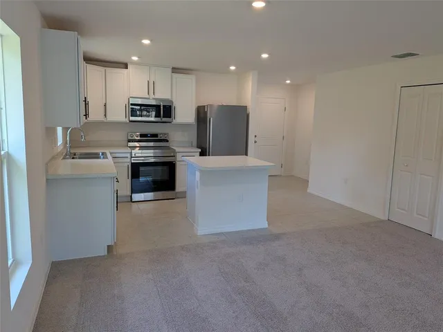 a kitchen with stainless steel appliances a refrigerator sink and stove