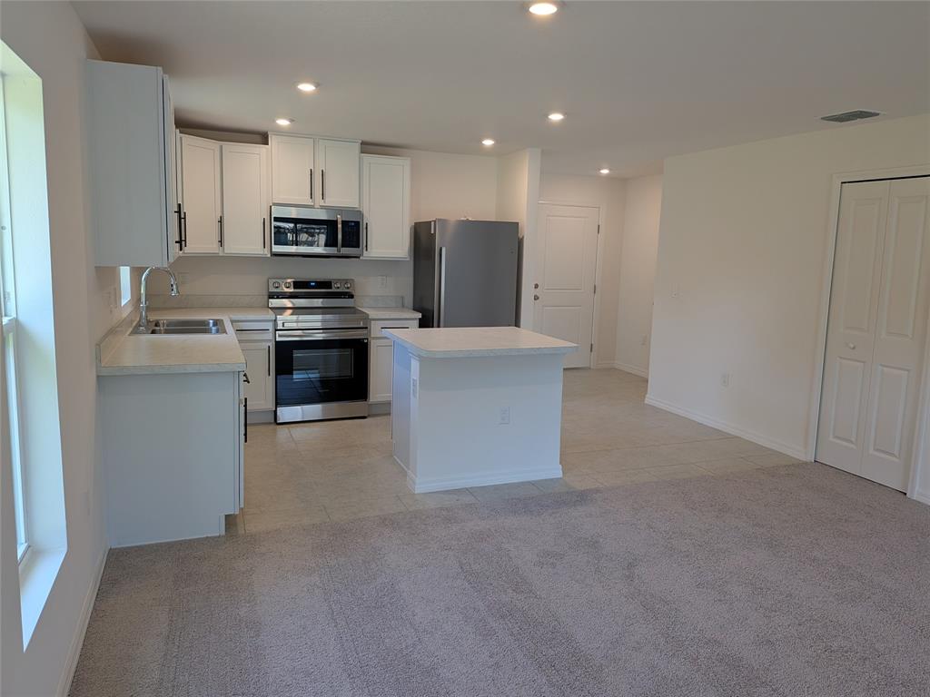9065 107th Court Vero Beach, FL 32967 - Photo 4 of 40 a kitchen with stainless steel appliances a refrigerator sink and stove
