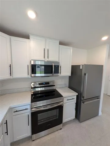 a kitchen with stainless steel appliances a refrigerator stove and microwave