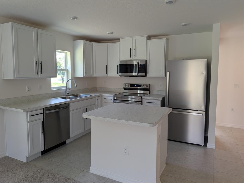 9065 107th Court Vero Beach, FL 32967 - Photo 6 of 40 a kitchen with a refrigerator sink and cabinets