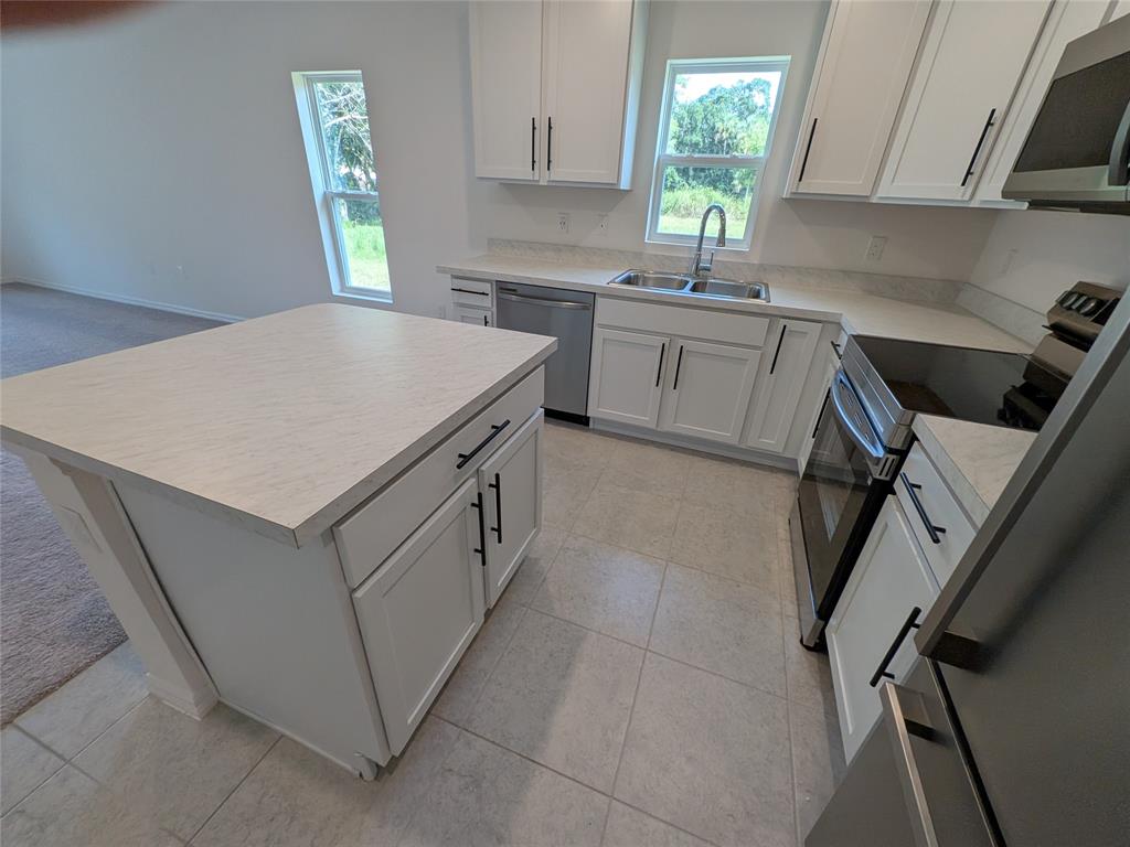 9065 107th Court Vero Beach, FL 32967 - Photo 8 of 40 a kitchen that has a sink a stove and cabinets