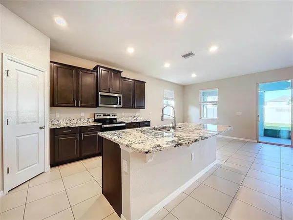 a kitchen with stainless steel appliances granite countertop a stove sink and cabinets